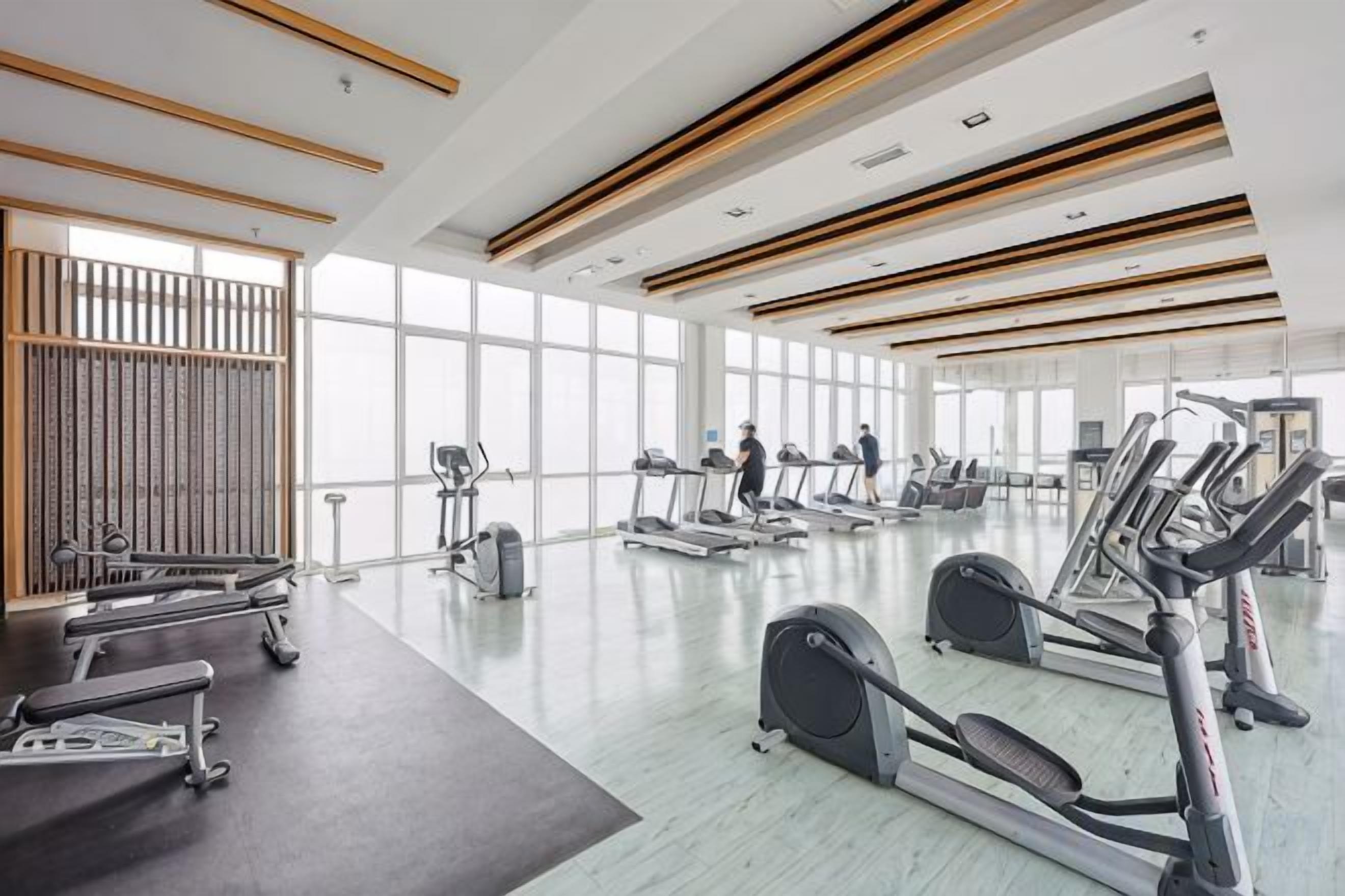 A spacious gym with treadmills, stationary bikes, and weight machines.