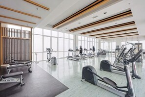 Un gimnasio amplio con cintas de correr, bicicletas estáticas y máquinas de pesas.