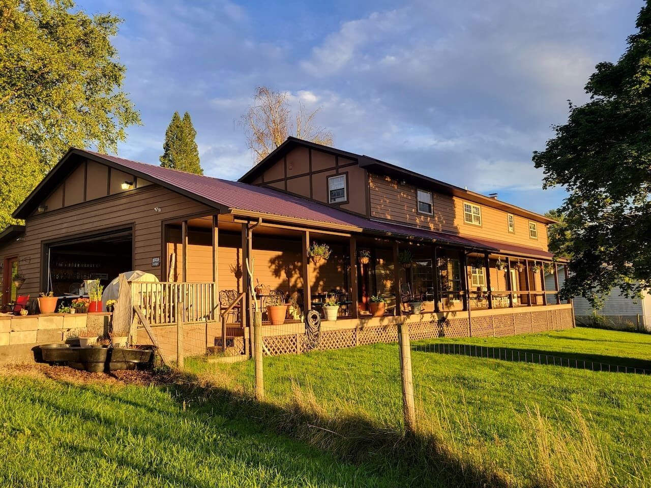 A two-story house with a covered porch, a garage, and a well-maintained lawn.