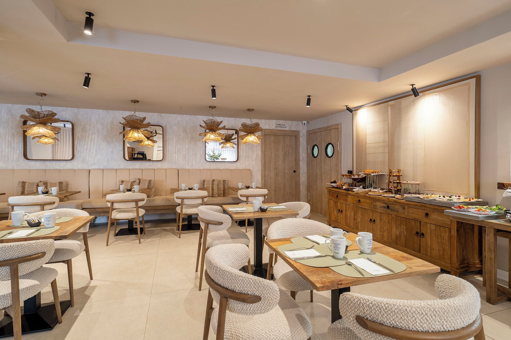 A restaurant with a long counter, multiple seating areas, and a variety of dishes displayed.
