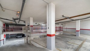 Un estacionamiento de varios niveles con pisos de concreto y barandillas de metal.