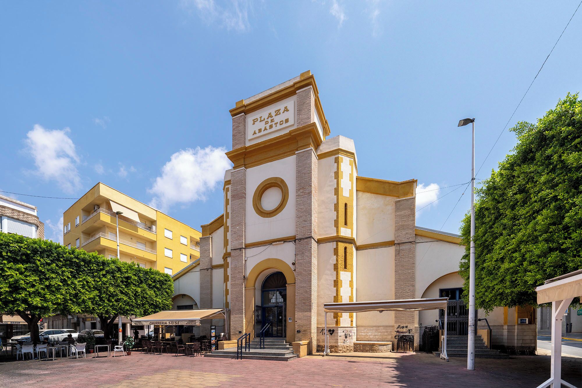 A building with a prominent entrance, a clock, and a sign above the door.