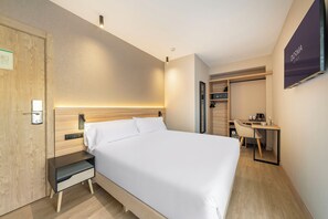 A modern hotel room with a bed, bedside table, and a desk with a chair. - Dorma Gaudea Santa Pola (Santa Pola)