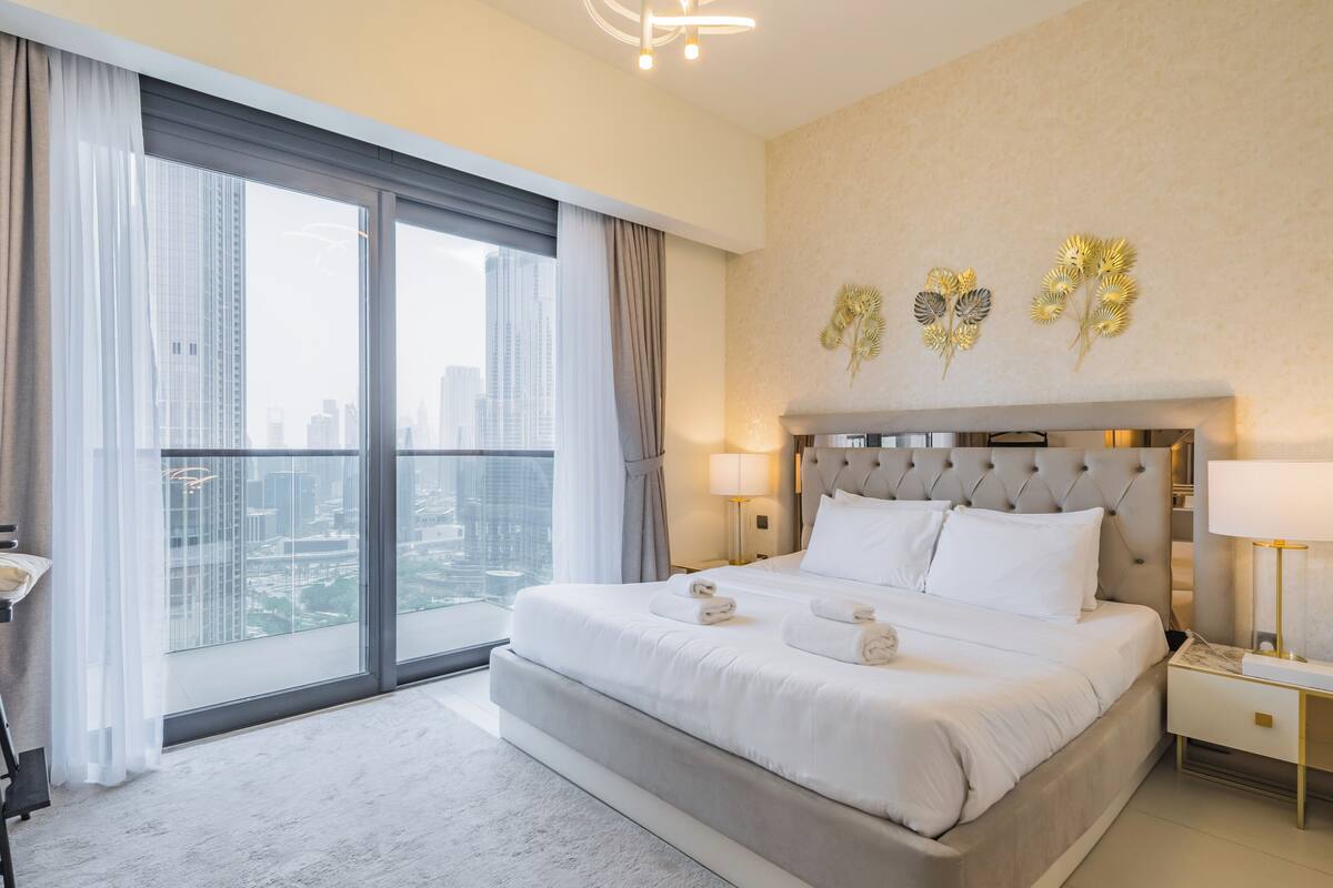 Ein modernes Hotelzimmer mit einem großen Bett, Blick auf die Stadt und Wandkunst.