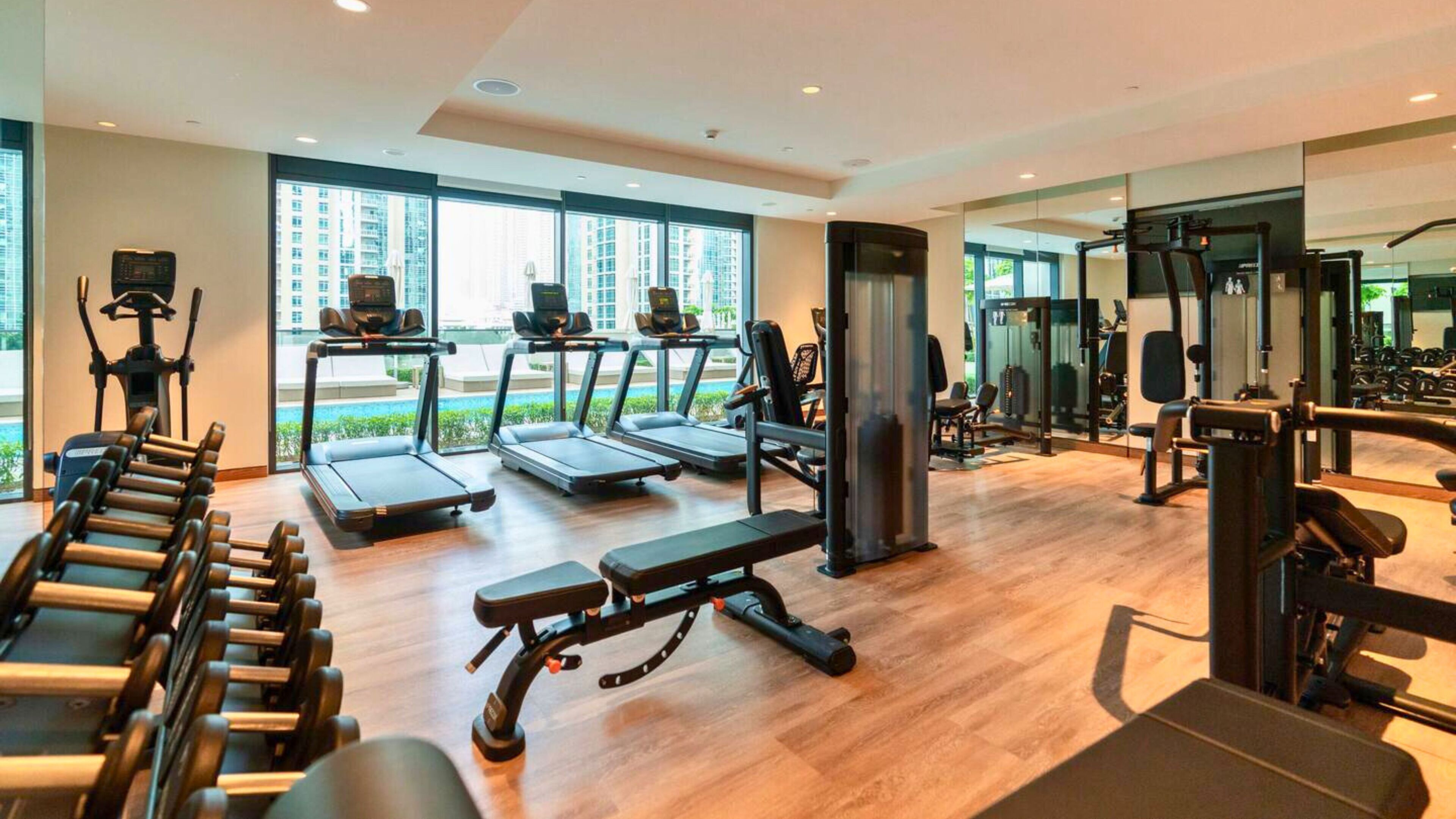 A modern gym with treadmills, weight machines, and benches.