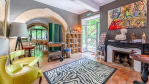 Una habitación con chimenea, un felpudo estampado de cebra, una estantería y un cuadro en la pared.