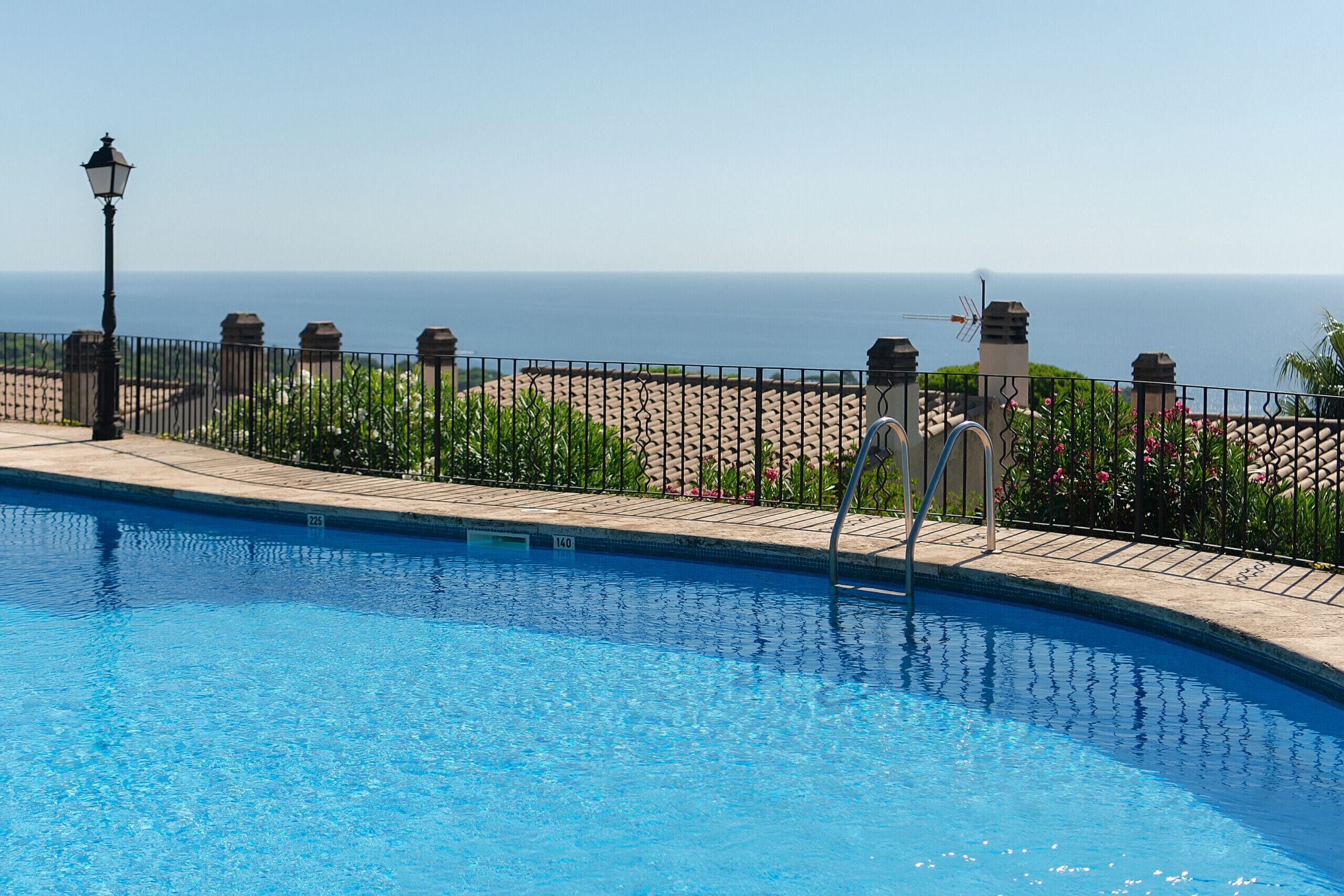 A swimming pool with a clear view of the ocean in the background.