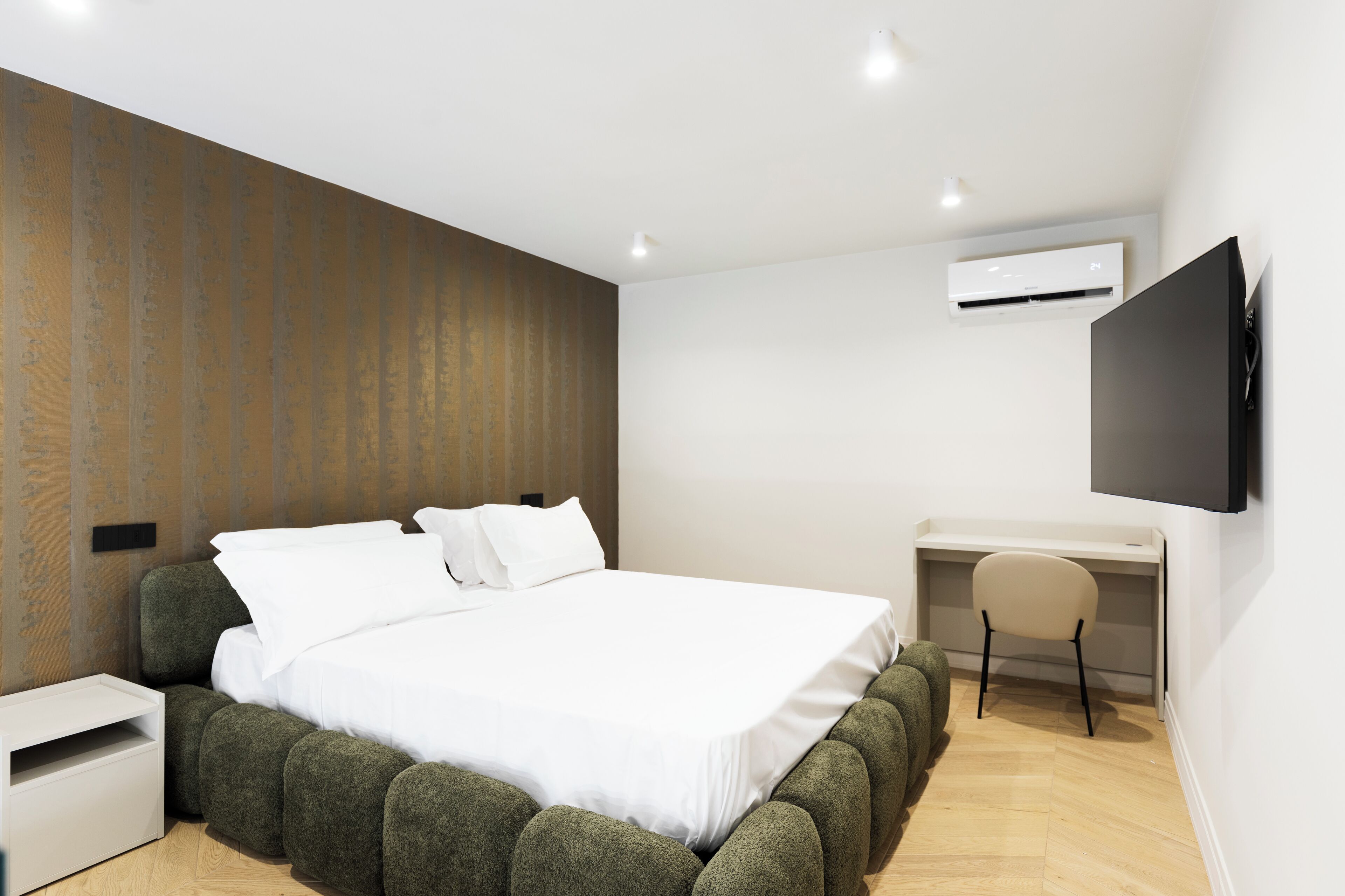 Ein modernes Schlafzimmer mit einem großen Bett, einem Schreibtisch und einem Stuhl.