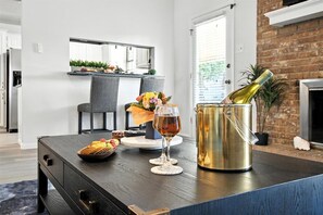 Een moderne keuken met een eethoek, een wijnglas en een fles wijn op een tafel.