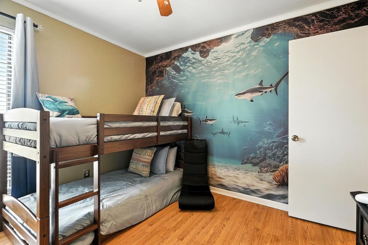 A bunk bed room with a mural of an underwater scene.