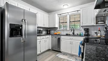 Un four, lave-vaisselle, cafetière-théière, chaise haute