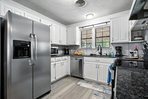 Ovn, oppvaskmaskin, kaffetrakter/tekoker og høy barnestol