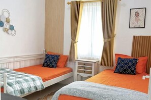 A room with two single beds, a small bedside table, and a window with curtains. - Premier inn homestay (Depok)