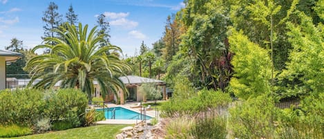 Una piscina al aire libre, sillones reclinables de piscina