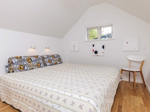 A bedroom with a bed, a chair, a window, and wall-mounted lights. - 6 Person Holiday Home in Stege (Stege)