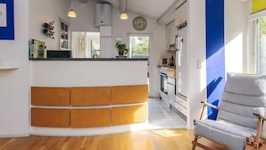 A modern kitchen with a central island, built-in appliances, and pendant lighting. - 6 Person Holiday Home in Stege (Stege)