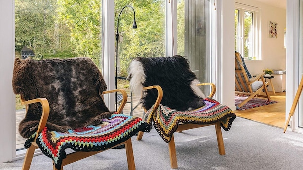 Two chairs with colorful crocheted seat covers in a room with large windows and a view of trees. - 6 Person Holiday Home in Stege (Stege)