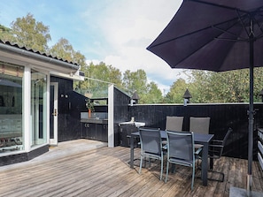 An outdoor patio with a wooden deck, a grill, and outdoor seating. - 6 Person Holiday Home in Stege (Stege)