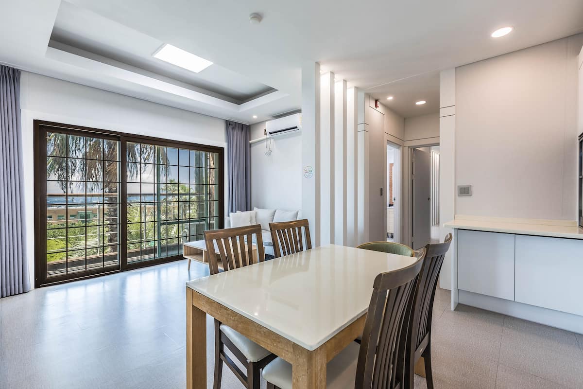 Una cocina moderna con comedor, ventanas amplias y vistas a la vegetación.