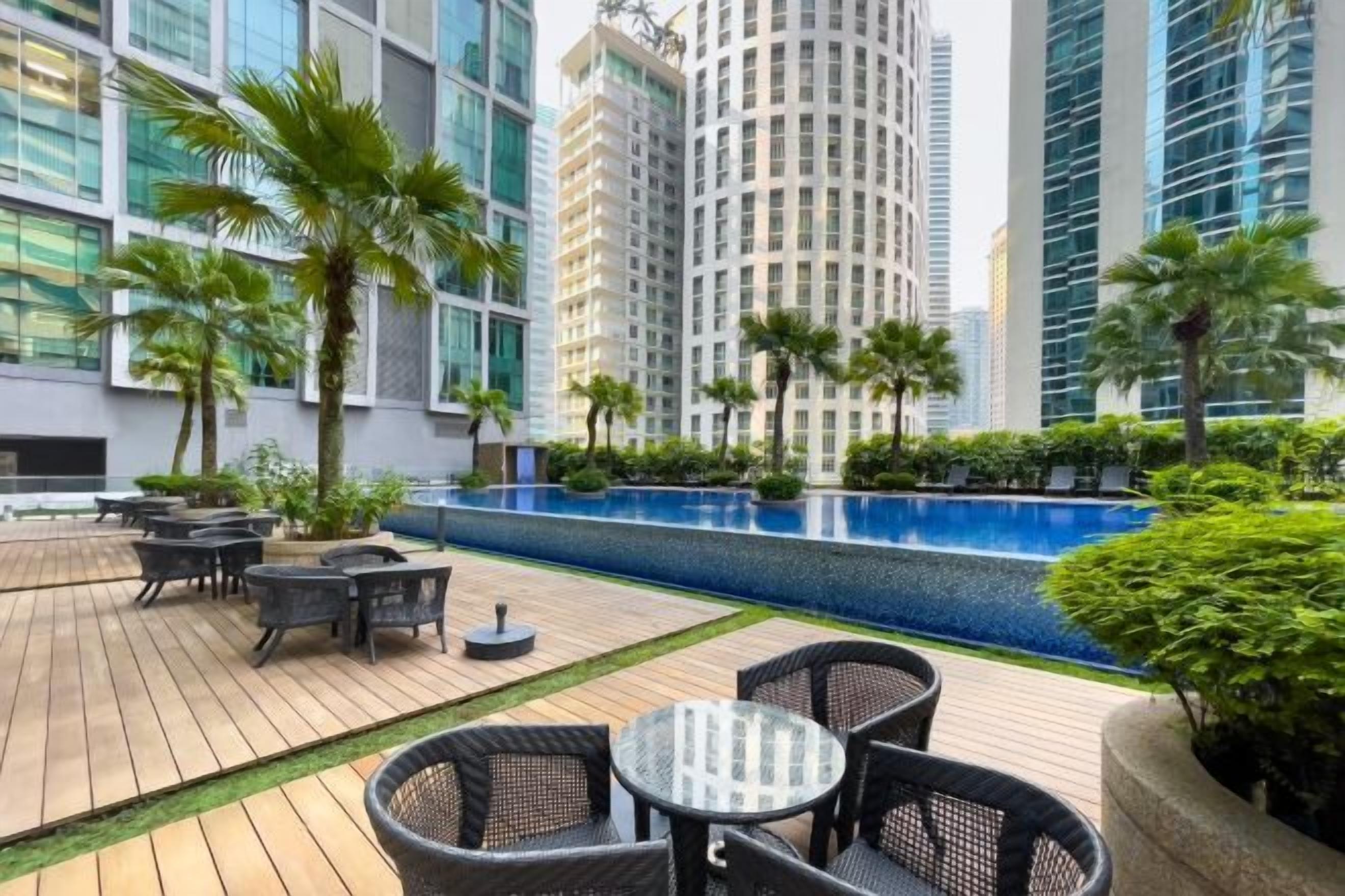 A rooftop patio with outdoor seating, a swimming pool, and high-rise buildings in the background.