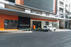 A modern building with a storefront labeled 'GSQUARE' and a white car parked in front. - RedDoorz Plus near Nakpil St. Taft Avenue (Manila)