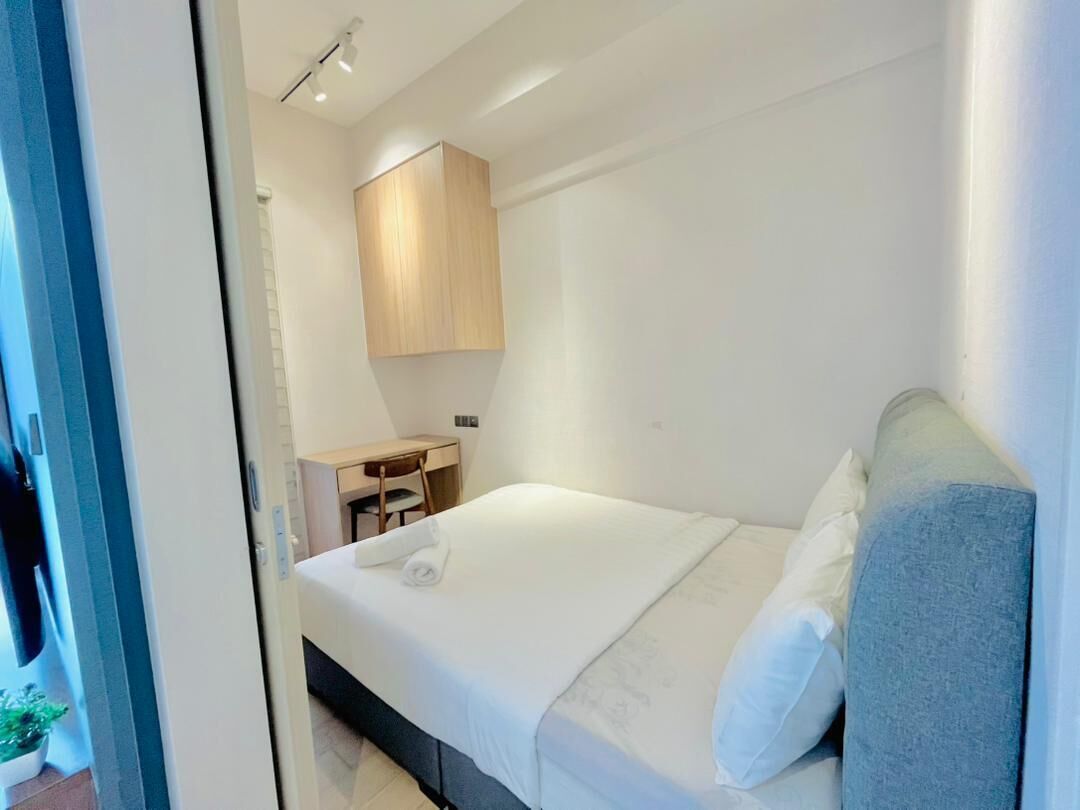Una habitación de hotel con cama, escritorio, silla y armario.