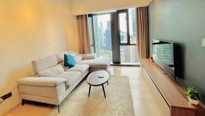 A modern living room with a sofa, a coffee table, and a TV on a wooden stand.
