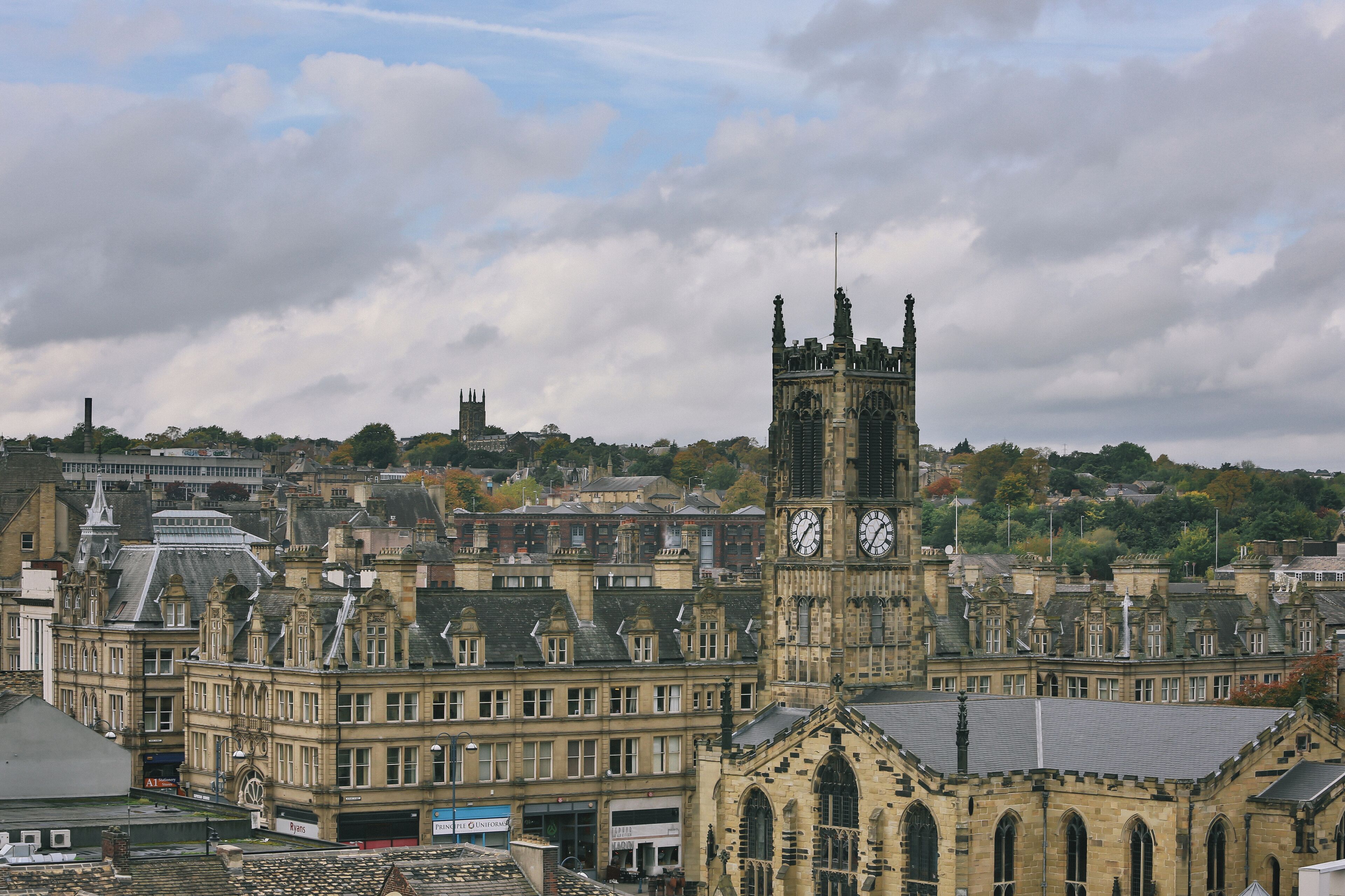 A historic building with a clock tower, featuring Gothic architecture and a prominent clock face.