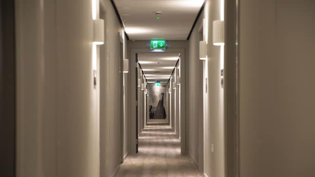 A long, narrow hotel corridor with a carpeted floor and walls on either side. - Student Only Oldgate House (Huddersfield)