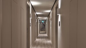 A long, narrow hallway with doors on both sides, leading to a central exit. - Student Only Oldgate House (Huddersfield)