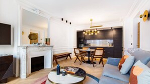 A modern living room with a fireplace, a dining area, and a kitchen. - #3Bedrooms#Lafayette#Paris10#AC (Paris)