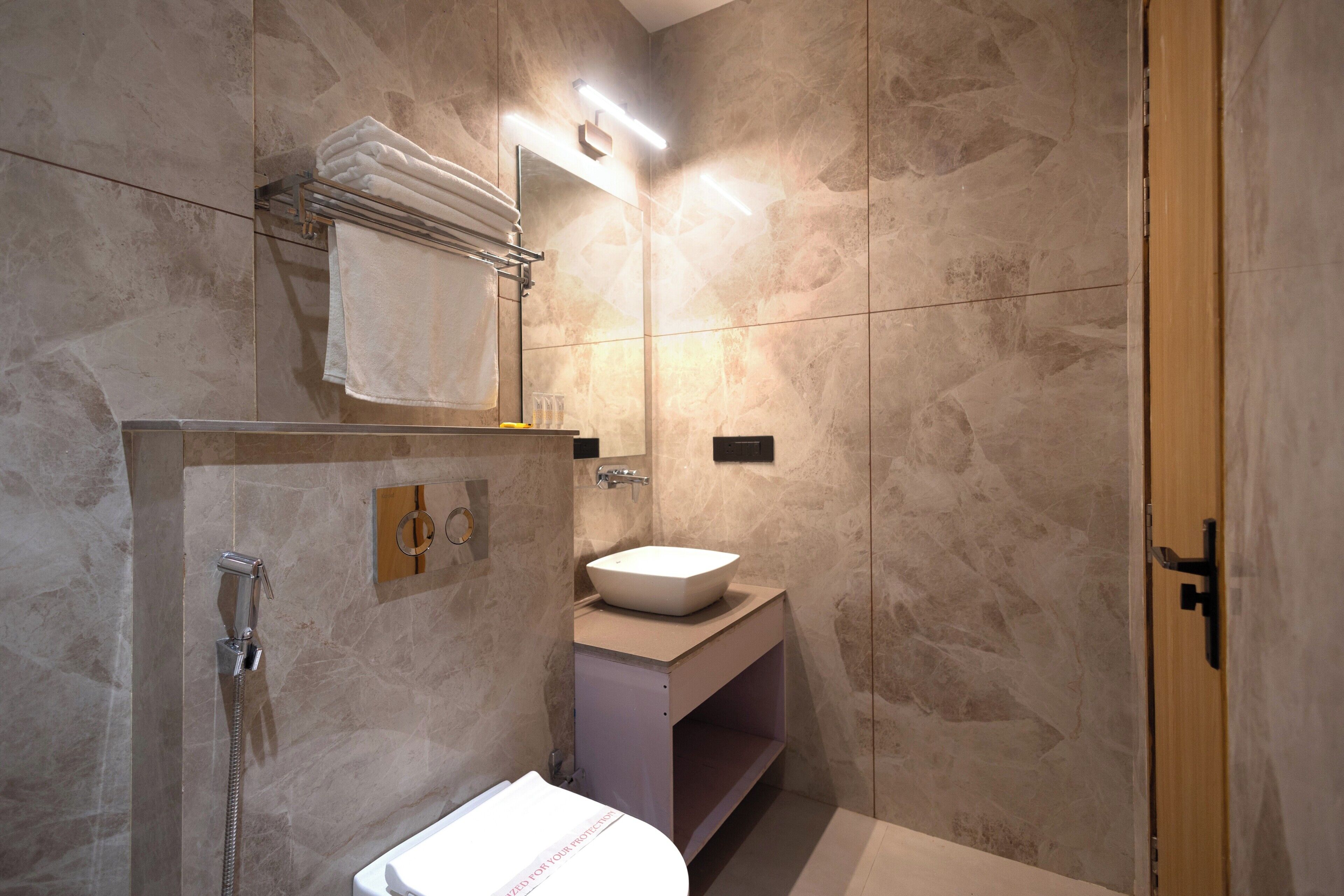 A bathroom with a shower, a sink, and a towel rack.