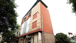 Un edificio a più piani con facciata piatta, un negozio a vista e un idrante antincendio all'esterno.