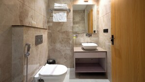 Un bagno moderno con doccia, WC, lavandino e specchio.