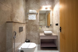 A modern bathroom with a shower, toilet, sink, and mirror. - Shri Govindam Banaras (Varanasi)
