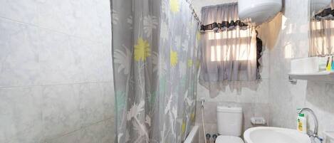 A bathroom with a bathtub, toilet, and sink.