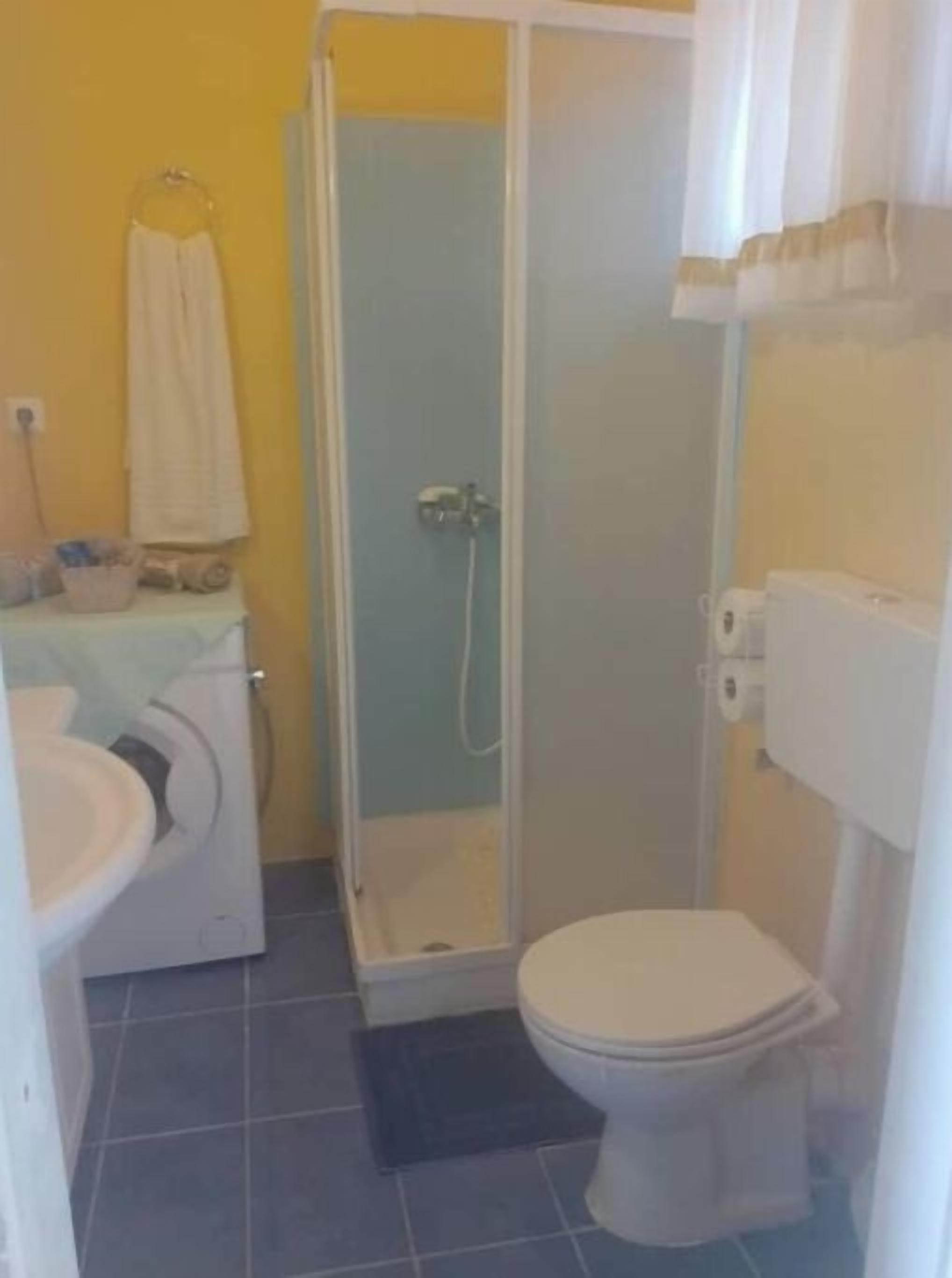 Un baño con inodoro, lavamanos y ducha.