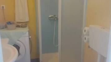 Un baño con inodoro, lavamanos y ducha.