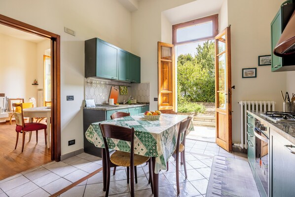 A kitchen with a dining table, chairs, and a view of the outdoors.