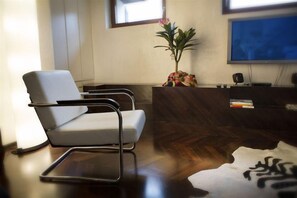 A modern reception area with a reception desk, a white chair, and a large window. - Truly Verona (Verona)