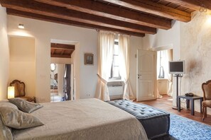 A bedroom with a bed, a window, a television, and a chair. - Truly Verona (Verona)
