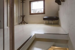 Une pièce avec une fenêtre, un banc et une petite table.