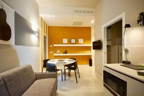 Una cocina moderna con comedor, sofá y televisor.