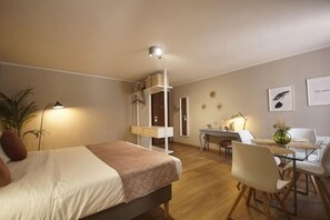 A hotel room with a bed, desk, chairs, and a small table. - Truly Verona (Verona)