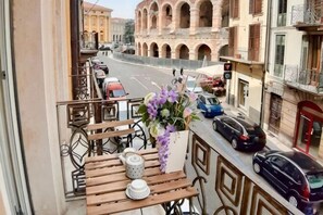 A balcony with a table, chairs, and a vase of flowers. - Truly Verona (Verona)