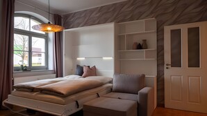 Een slaapkamer met een bed, nachtkastjes, een kledingkast en een raam met gordijnen.