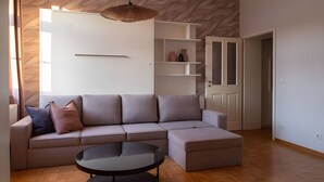 Een moderne woonkamer met een modulaire bank, een ronde salontafel en inbouwplanken.