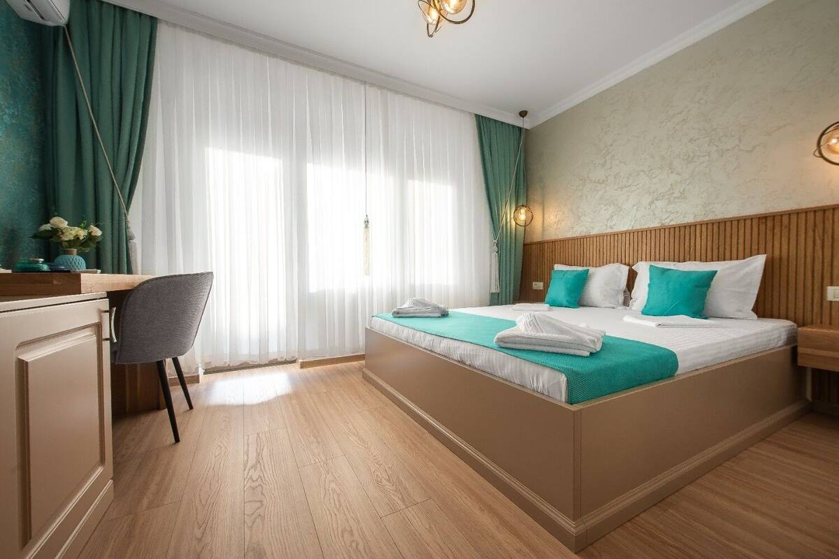Una habitación de hotel con una cama, un escritorio y una silla.