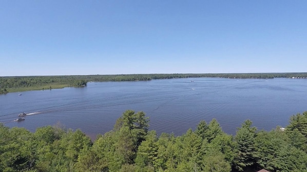 A large body of water with boats, surrounded by dense forest.