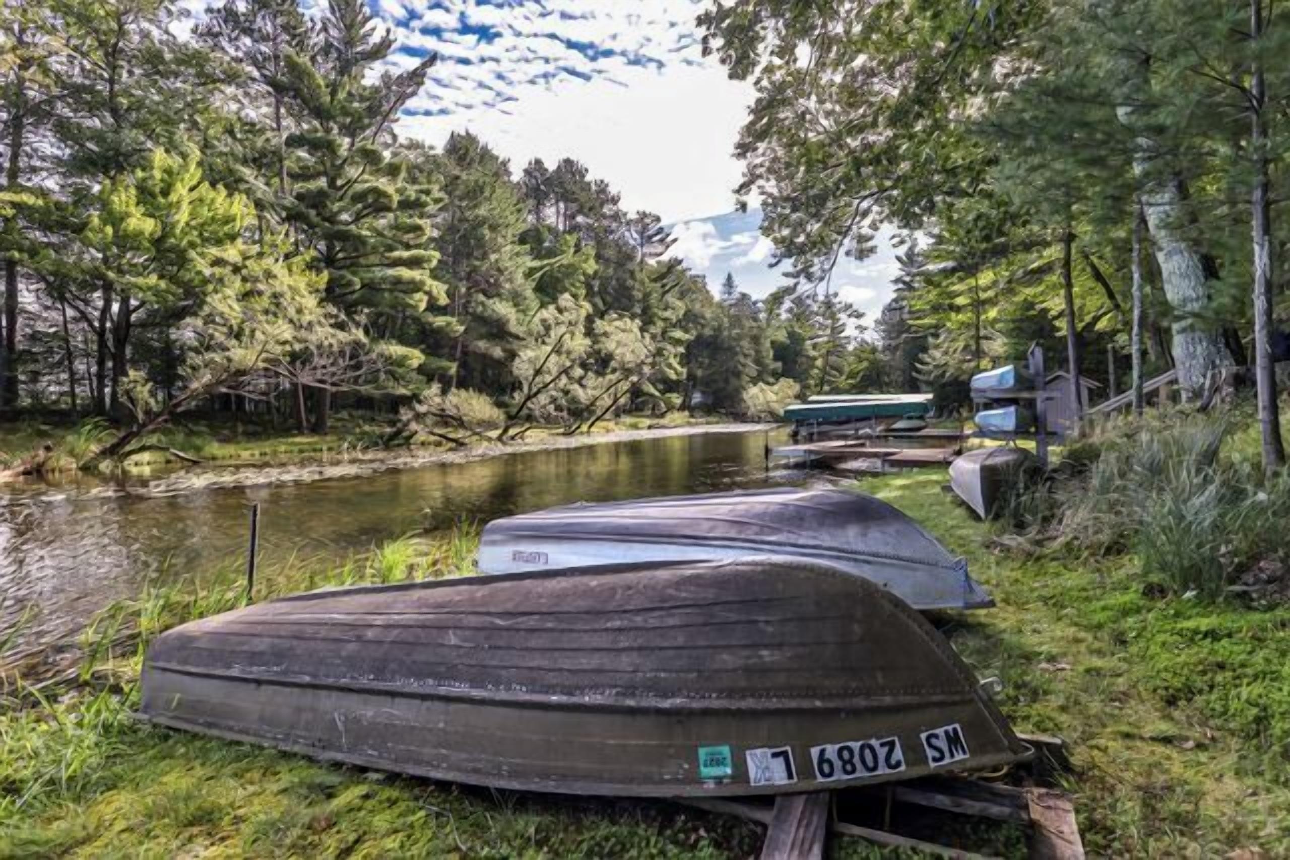 Tres barcos estacionados junto a un río tranquilo bordeado por árboles.